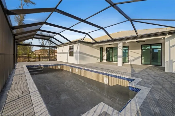 View of swimming pool featuring a lanai, ceiling fan, and a patio area