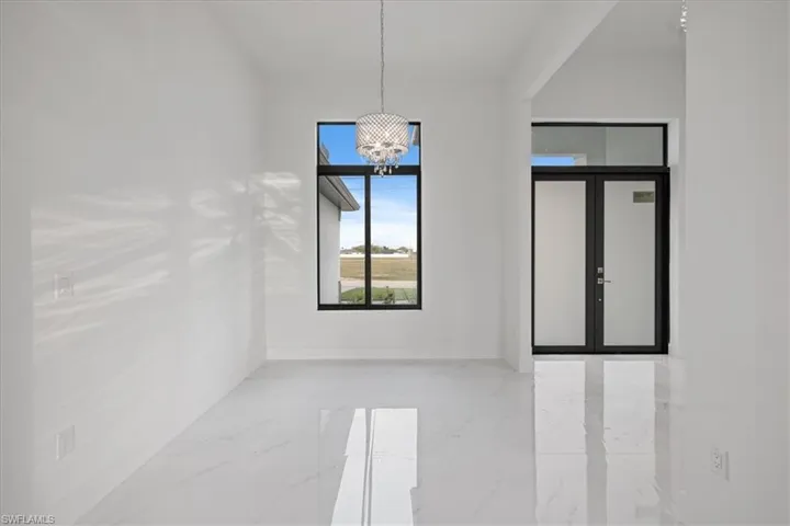 Empty room with an inviting chandelier and french doors