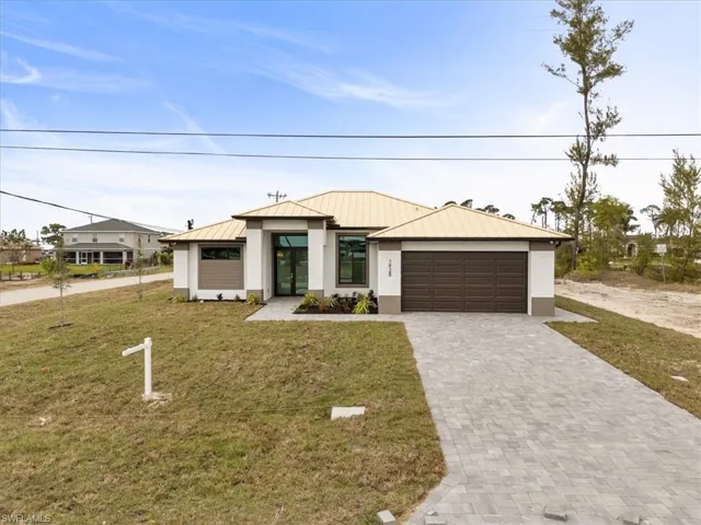 View of front of house featuring a garage and a front yard
