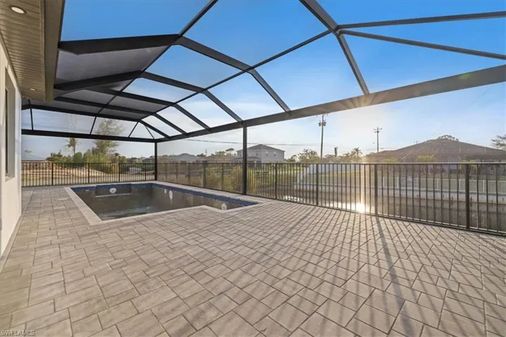 View of pool with glass enclosure and a patio area