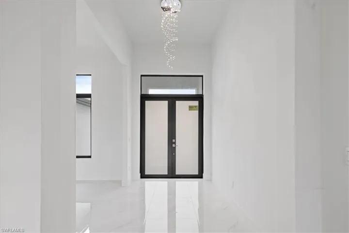 Foyer entrance featuring a chandelier and french doors