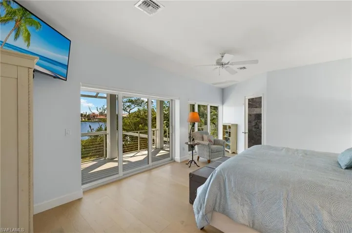 Bedroom featuring wood finished floors, access to outside, and ceiling fan