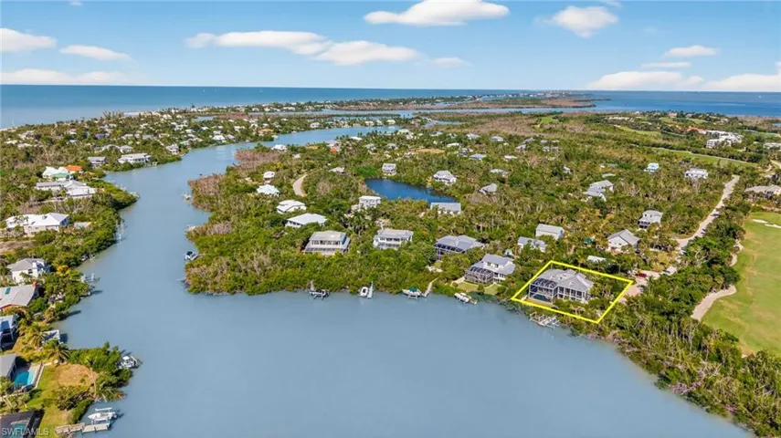 Aerial view of property and surrounding area featuring property parcel outlined and a large body of water