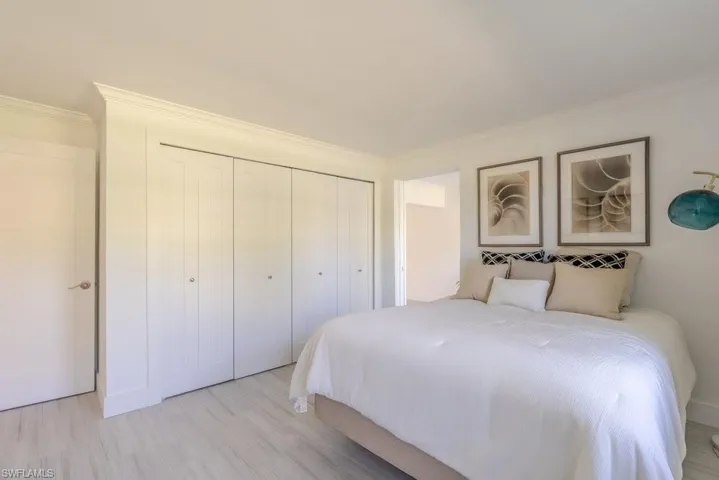 Bedroom featuring crown molding, wood finished floors, and a closet