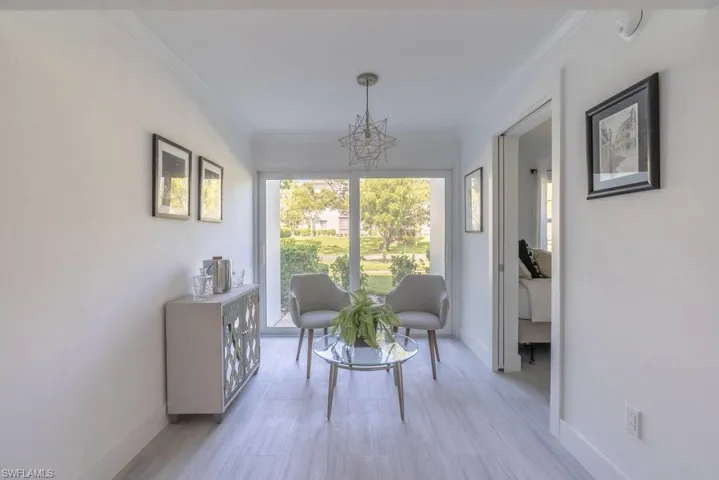 Living area featuring ornamental molding and a chandelier