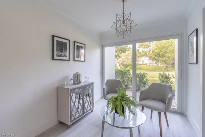 Living area with baseboards and crown molding