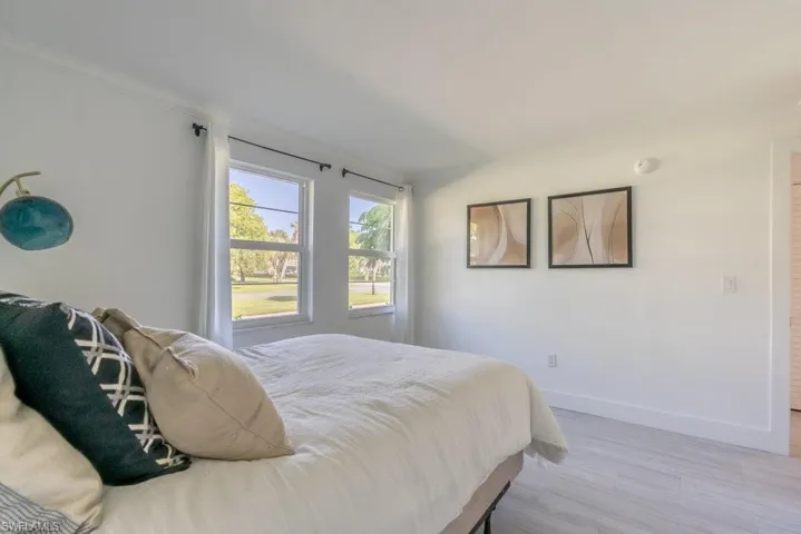 Bedroom featuring light wood-style flooring and ornamental molding