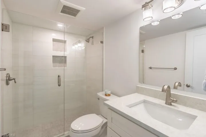 Full bathroom with vanity, a shower stall, and recessed lighting