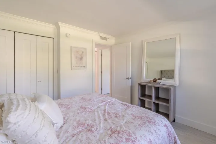 Bedroom with crown molding, a closet, and wood finished floors