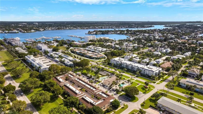 Aerial view of property's location featuring a nearby body of water and a marina