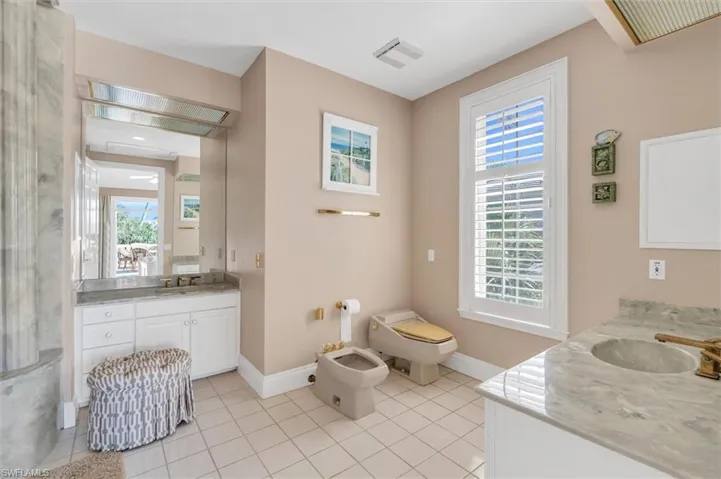 Bathroom featuring vanity, a wealth of natural light, a bidet, and tile patterned floors