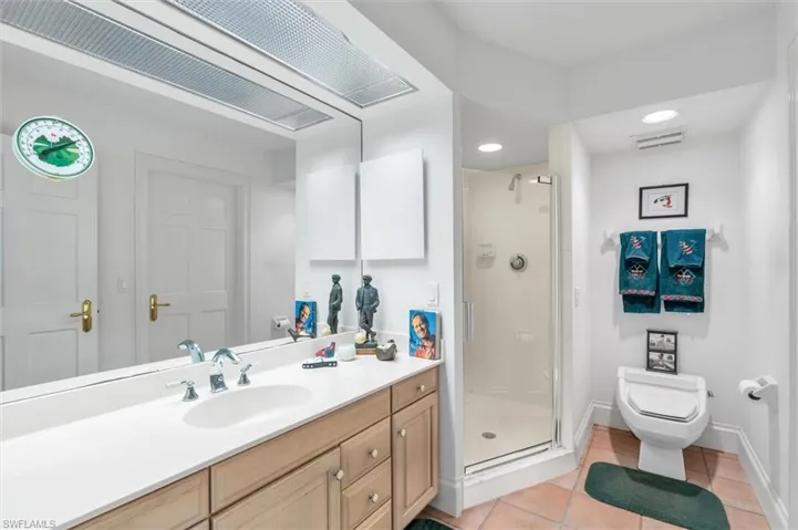Bathroom with walk in shower, vanity, toilet, and tile patterned floors