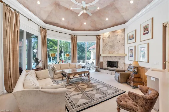 Floor to Ceiling Windows with Pool & Golf Course Views. Coral Stone Fireplace