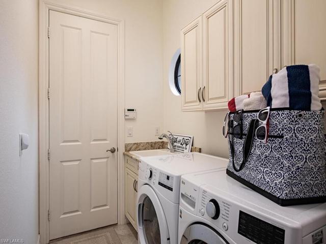 Laundry in residence, with laundry sink & storage cabinets
