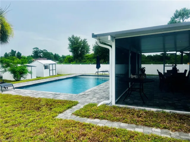 View of swimming pool with an outdoor structure and a patio area