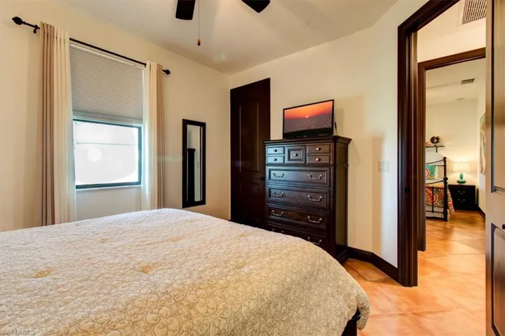 Bedroom with light tile patterned floors and ceiling fan