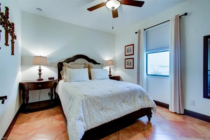 Bedroom featuring light tile patterned floors and ceiling fan