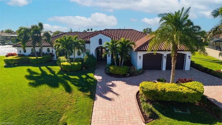 Mediterranean / spanish-style house featuring a garage and a front lawn