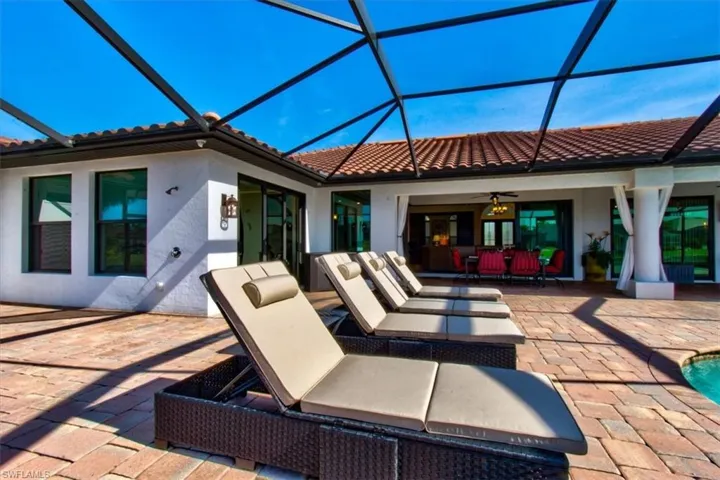 View of patio featuring glass enclosure and ceiling fan