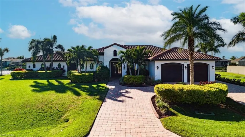 Mediterranean / spanish-style home featuring a garage and a front yard