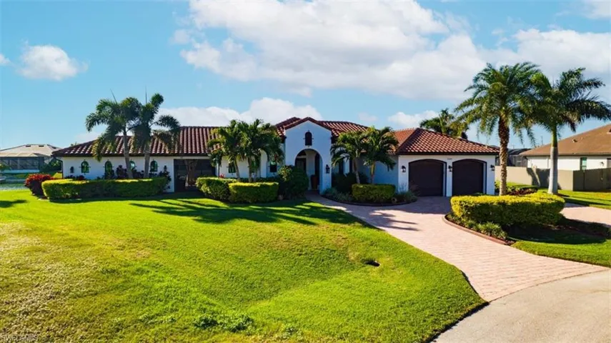 Mediterranean / spanish-style home featuring a garage and a front yard