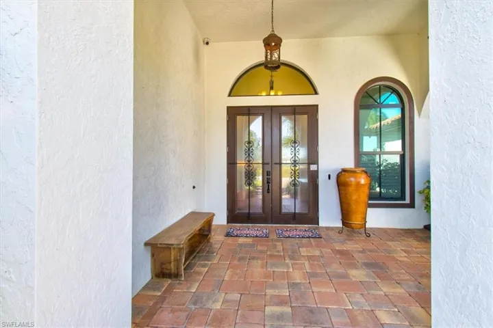 Property entrance with covered porch and french doors