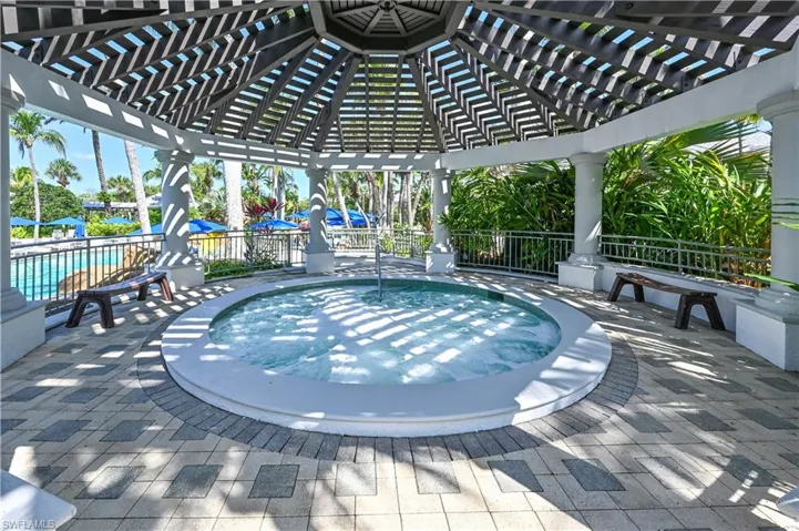 View of swimming pool with a pergola, patio surround, a pool, and a community hot tub