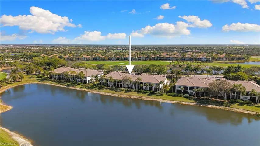 Aerial view of residential area featuring a nearby body of water and a golf club