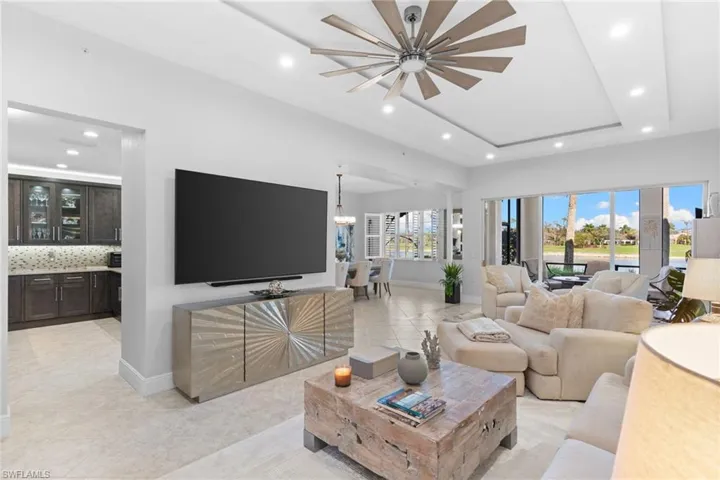 Living area featuring recessed lighting, a ceiling fan, light tile patterned flooring, and a raised ceiling