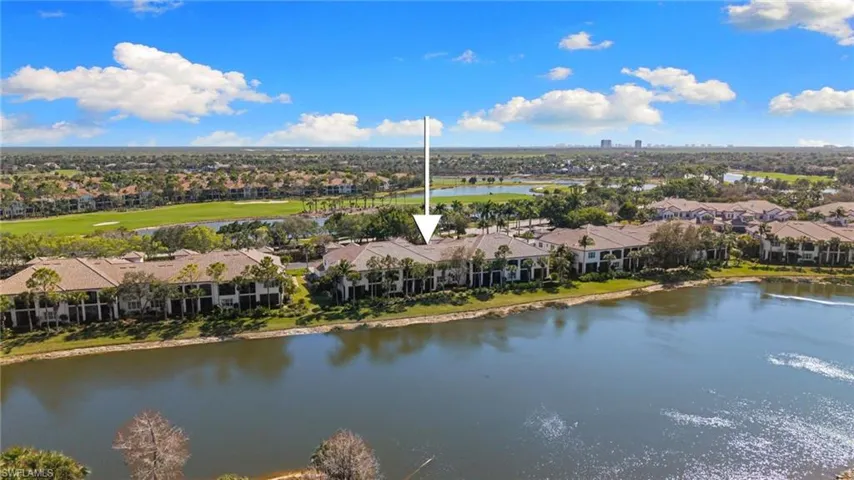 Aerial view of residential area featuring a large body of water and a golf course