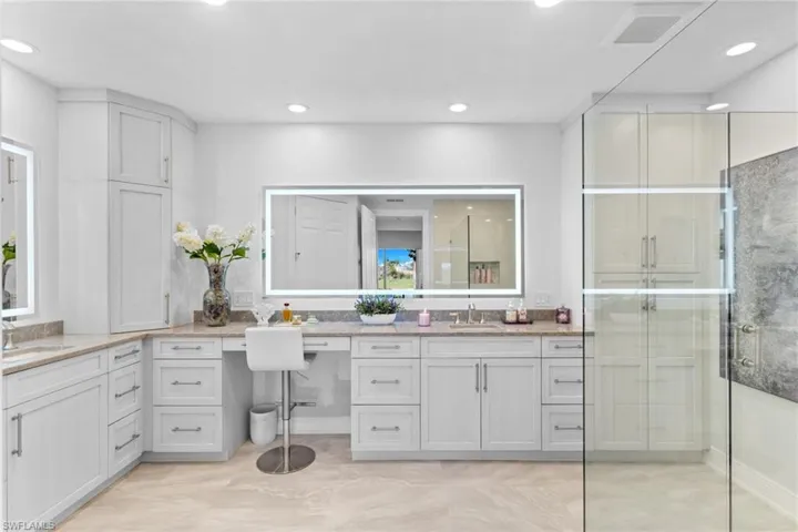 Bathroom with a stall shower, vanity, and recessed lighting
