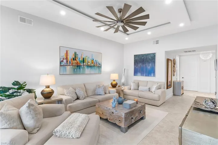 Living area featuring recessed lighting, a raised ceiling, and ceiling fan