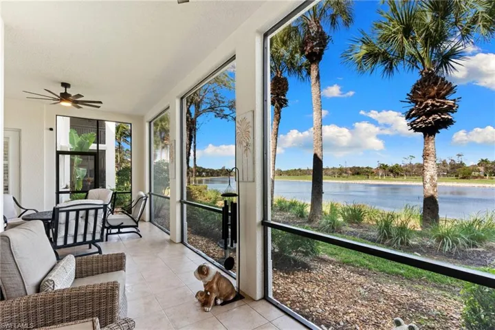 Sunroom / solarium featuring tile patterned flooring and a water view