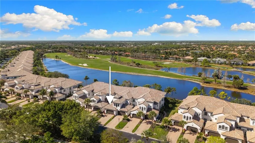Aerial perspective of suburban area with a nearby body of water and a local golf course