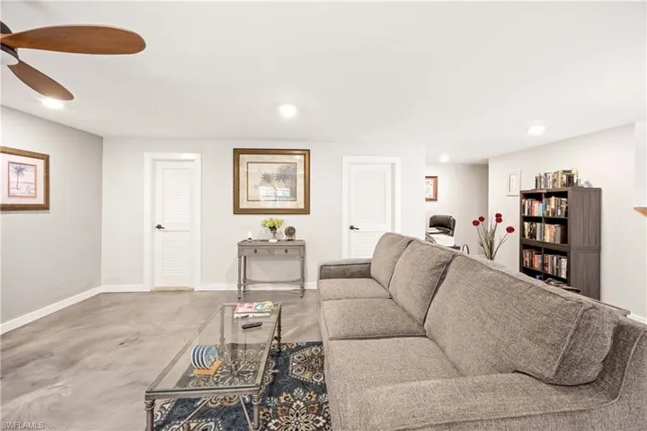 Living room featuring ceiling fan and concrete flooring