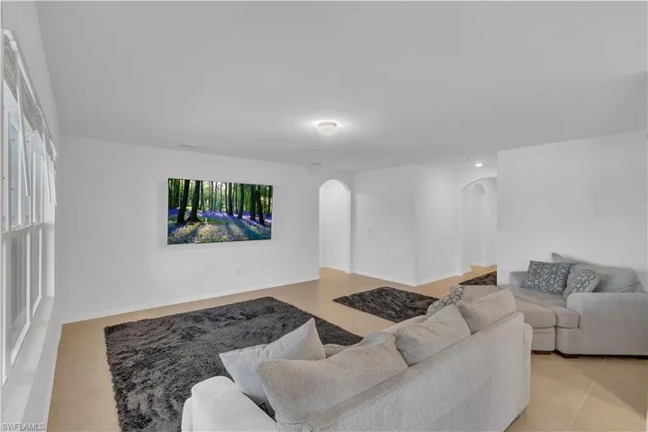 Living room with light tile patterned floors and arched walkways