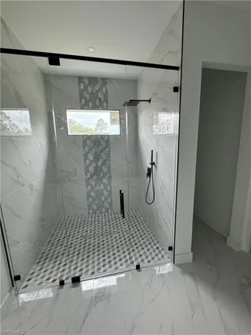Bathroom with walk in shower and tile patterned floors