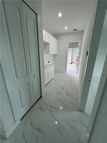 Hallway featuring light tile patterned floors