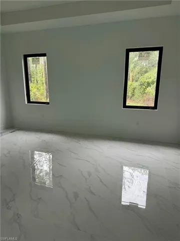 Empty room featuring a wealth of natural light and light tile patterned floors