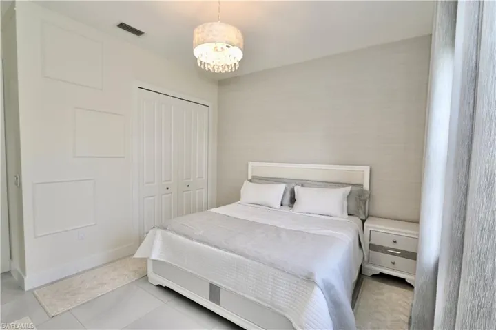 Bedroom with a closet, a chandelier, and light tile patterned flooring
