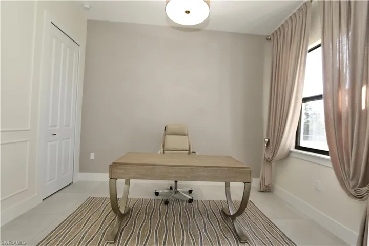 Office space featuring light tile patterned floors and baseboards