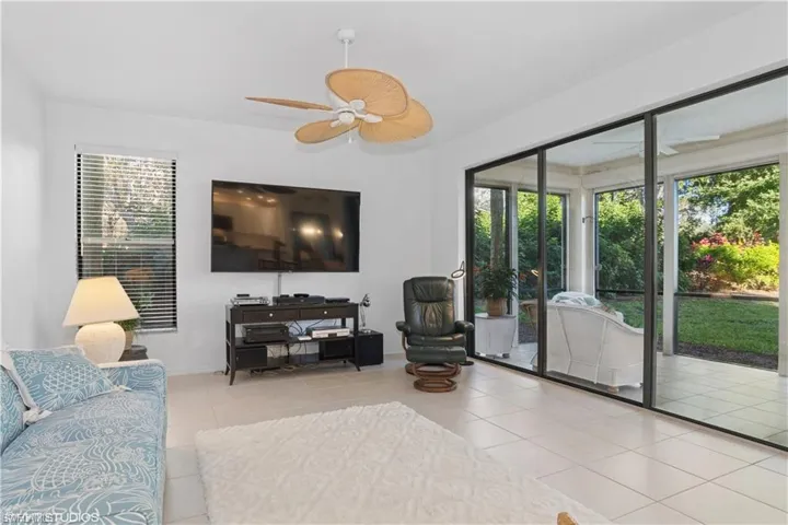 Living room featuring a ceiling fan and tile patterned flooring