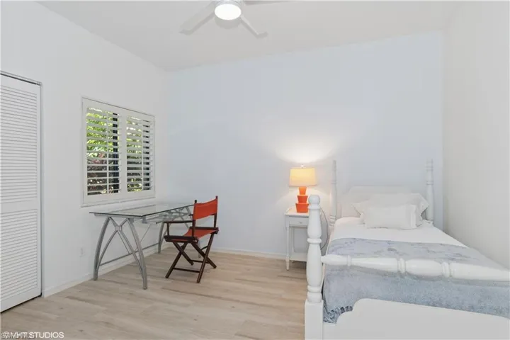 Bedroom with a ceiling fan, a closet, baseboards, and wood finished floors