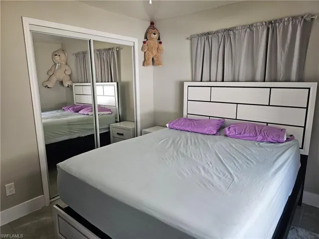 Bedroom with a closet and dark tile patterned floors
