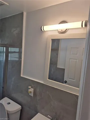 Bathroom with tile walls and toilet