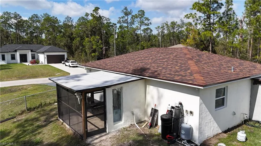 Back of house featuring a lawn and a sunroom