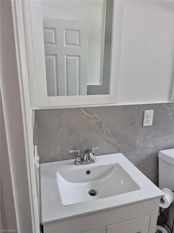 Bathroom with tasteful backsplash, vanity, and toilet