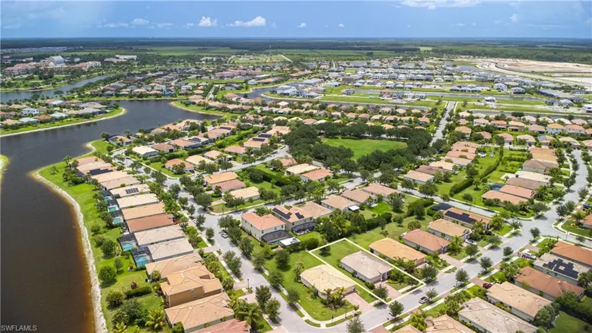 Aerial view of property and surrounding area with nearby suburban area and a large body of water