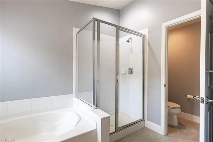 Full bath with a shower stall and a garden tub