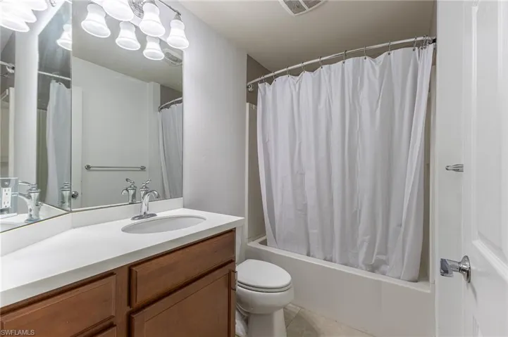 Full bathroom featuring vanity, shower / bath combination with curtain, and tile patterned floors